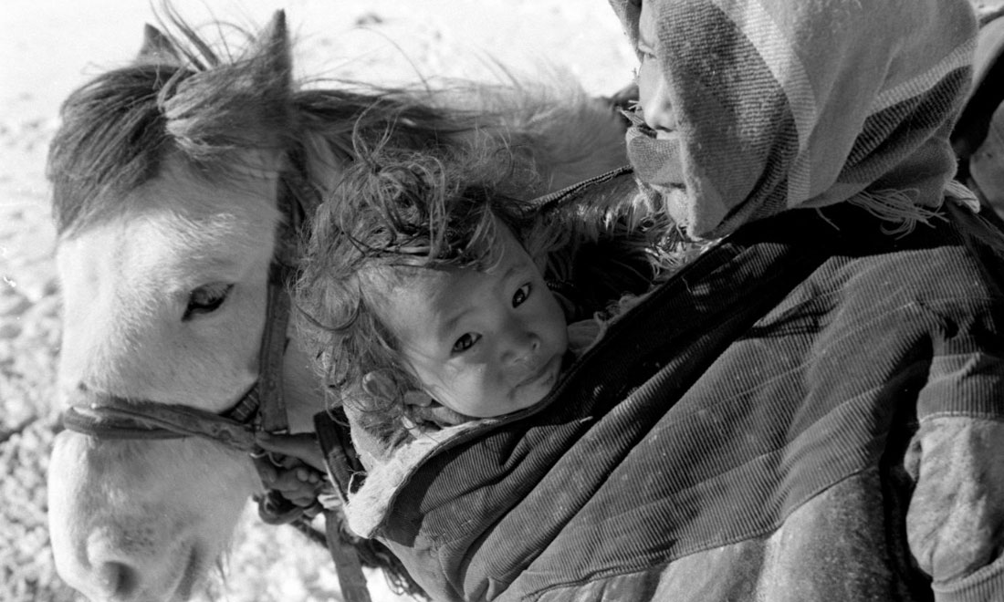 1990年3月，西藏當(dāng)雄縣納木湖鄉(xiāng)三村女牧民斯卓不畏嚴(yán)寒，懷抱幼子，準(zhǔn)備到遠(yuǎn)處放牧。新華社記者覺(jué)果攝