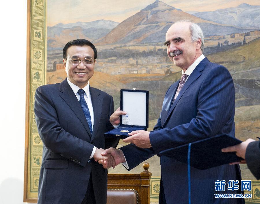 6月19日，國務院總理李克強在希臘議會大廈會見希臘議長米馬拉基斯。這是會見前，米馬拉基斯代表希臘議會向李克強授予議會金質(zhì)勛章。新華社記者 王曄 攝