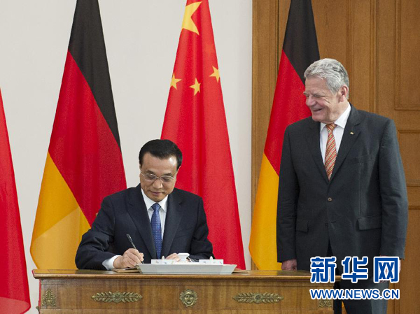 10月10日，國務(wù)院總理李克強在柏林會見德國總統(tǒng)高克。這是李克強總理在高克總統(tǒng)的陪同下在貴賓簿上簽字。 新華社記者 王曄 攝 